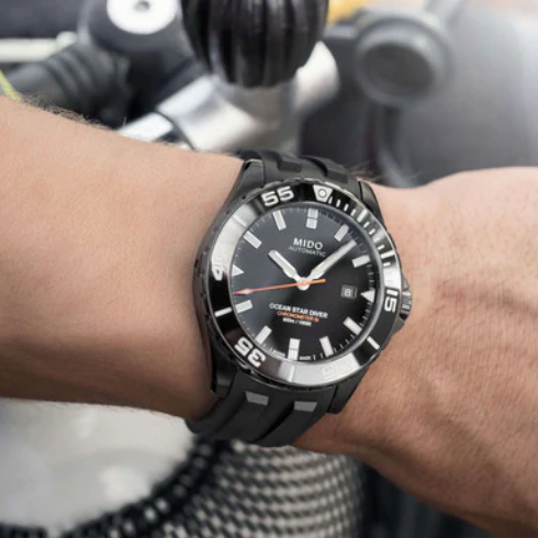 Orologio da uomo solo tempo automatico della collezione Mido Watches modello Ocean Star Diver 600 Cassa in acciaio inossidabile con diametro di 43,5 mm e spessore di 14,05 mm Quadrante di colore nero con lancette e indici di colore bianco, datario a ore 3 e lancetta dei secondi di colore arancione Lunetta completamente riempita di Super Luminova Grado X ® Vetro zaffiro antigraffio con trattamento antiriflesso Movimento automatico Mido Calibro 80 su base ETA C07.821 con riserva di carica fino a 80 ore Res