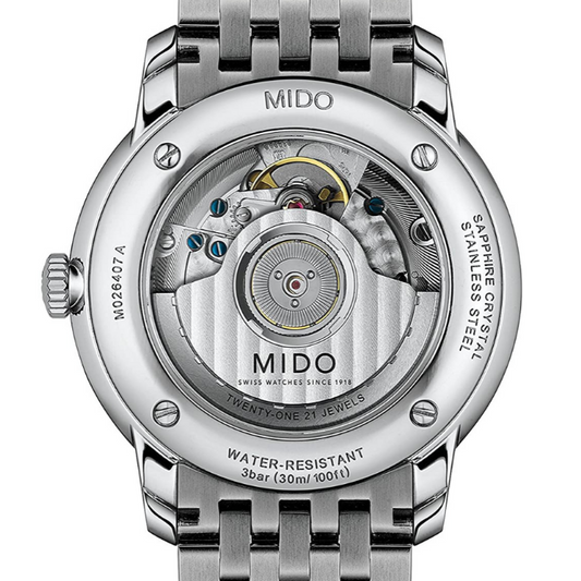 Orologio da uomo solo tempo automatico della collezione Mido Watches modello Baroncelli Heritage Cassa in acciaio inossidabile con diametro di 39 mm, spessore di 7,25 mm e fondello a vista che lascia intravedere il meccanismo automatico dell'orologio Quadrante di colore bianco con indici e lancette di colore nero e datario a ore 3 Vetro zaffiro antigraffio con trattamento antiriflesso Movimento automatico Mico calibro 1192 su base ETA 2892A2 Resistente all'acqua fino a 30 metri (3 bar) Cinturino in acci