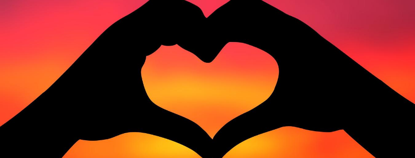 Idee regalo compleanno moglie - due mani formano un cuore al tramonto