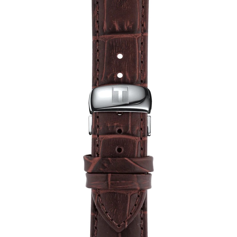 Orologio da uomo solo tempo al quarzo della collezione T-Classic Tissot modello Tradition  Cassa in acciaio inossidabile con diametro di 42 mm e spessore di 7,5 mm  Quadrante color argento con disegno quadrettato, indici romani e lancette color argento e datario a ore 3 Vetro zaffiro antigraffio  Movimento svizzero al quarzo calibro ETA F06.111 Resistente all'acqua fino a 30 metri (3 bar) Cinturino in pelle marrone con stampa effetto alligatore e chiusura a farfalla Codice prodotto: T0636101603800